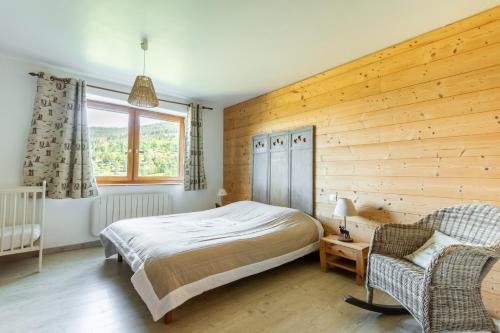 - une chambre avec un lit et un mur en bois dans l'établissement Les Pistes de Ventron, à Ventron