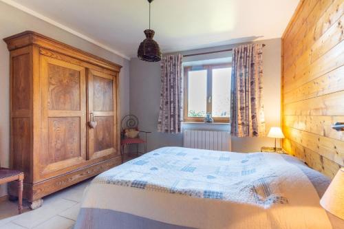 a bedroom with a bed and a wooden cabinet at Les Pistes de Ventron in Ventron
