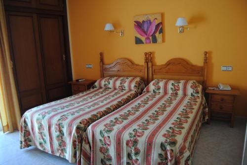a bedroom with a bed with a comforter at Hostal Italia in Fuengirola