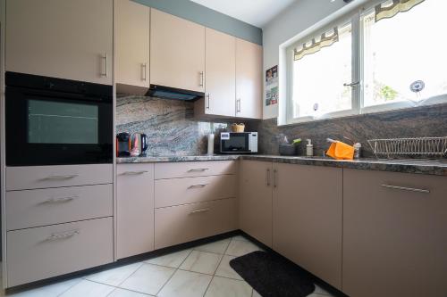 a kitchen with white cabinets and a black microwave at la viela in Fleurier