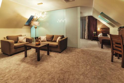 a living room with a couch and a table at Złoty Groń Resort & Spa in Istebna
