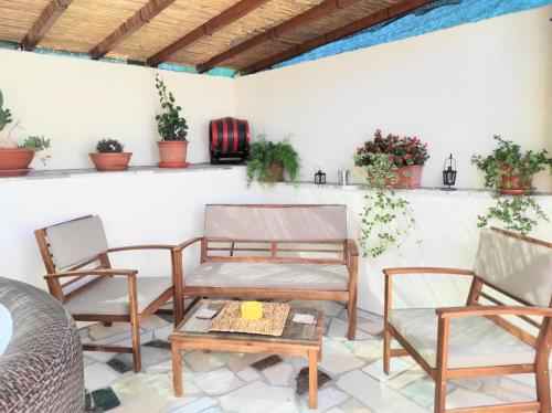 a patio with three chairs and a table at HOLIDAY HOME ZLOPOJE in Vis