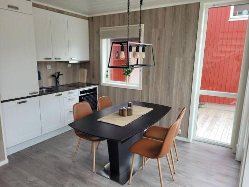 a kitchen with a black table and chairs in it at Waterfront Ballstad, Lofoten in Ballstad