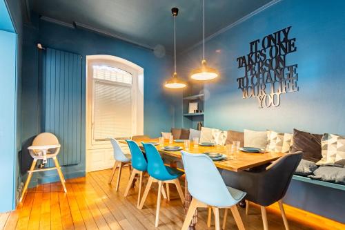 une salle à manger avec une table en bois et des chaises bleues dans l'établissement Les Libellules - Maison de caractère 5ch, à Gérardmer