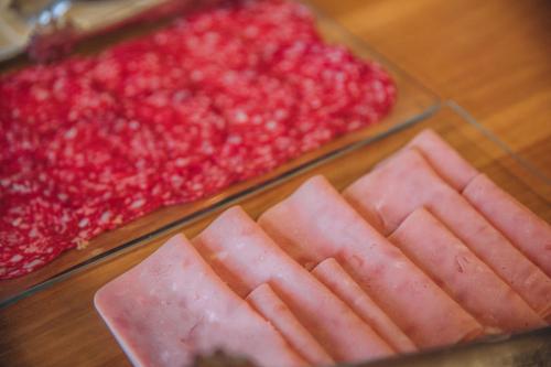 two trays of ham and red meat on a table at Hotel Arha Mar Comillas in Comillas