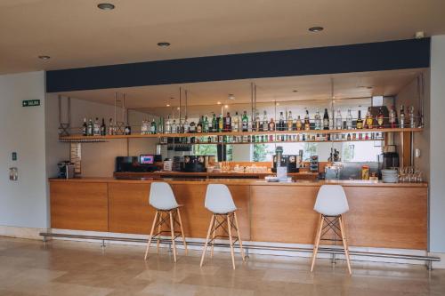 a bar with three stools in front of it at Hotel Arha Mar Comillas in Comillas