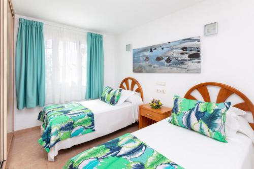 een hotelkamer met twee bedden en een raam bij MUR Bungalows Parque Romantico in Playa del Inglés