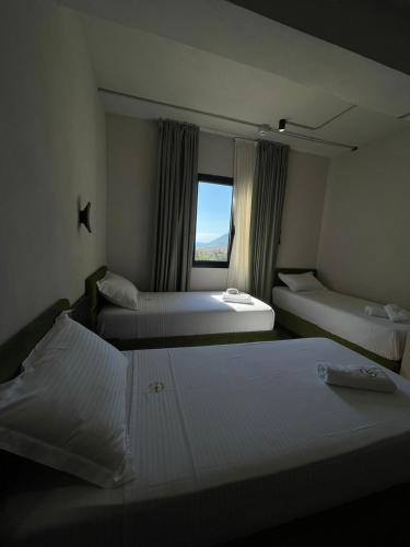 a hotel room with two beds and a window at Gogo's Boutique Hotel in Dhërmi
