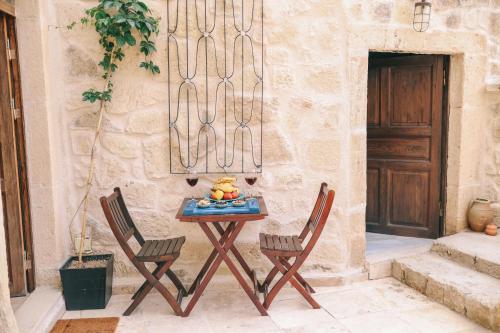 a table with two chairs and a bowl of fruit on it at Elaa Cave Hotel in Ortahisar