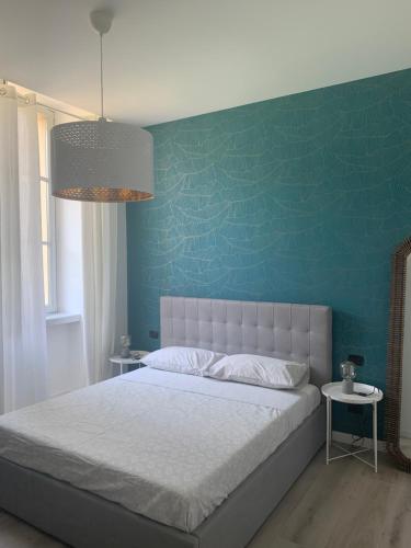 um quarto com uma cama com uma parede azul em MARTI' S HOUSE em Olginate