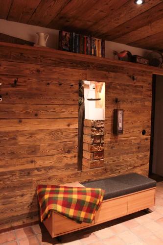 a room with a wooden wall with a bench at Die Mirnockhütte in Ferndorf