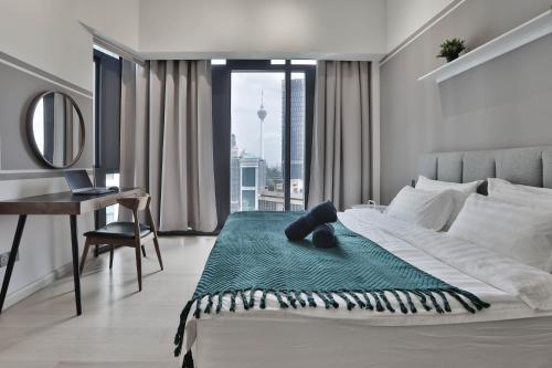 H&N Luxury Suites KLCC في كوالالمبور: غرفة نوم مع سرير مع مكتب ونافذة
