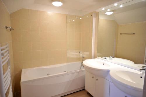 a bathroom with a sink and a tub and a toilet at Lagrange Vacances - Résidence Jardin Mauresque in Arcachon