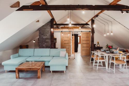 a living room with a blue couch and a table at Projekt 44 Apartament in Oświęcim