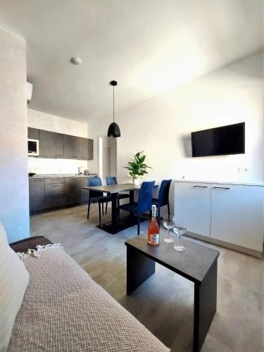 a kitchen and a living room with a table and chairs at BAUR SUITE - Regarda Travel in Bardolino