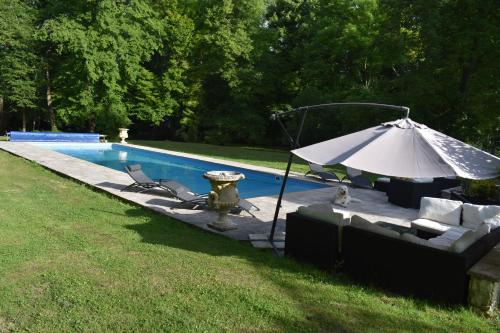 une bouche d'incendie et un parasol à côté d'une piscine dans l'établissement LA DEMEURE DE LA JUINE, à Morigny-Champigny