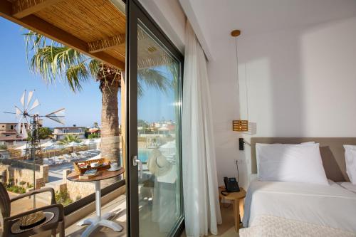a bedroom with a bed and a view of the ocean at Aloe Boutique Hotel Powered By Anissa in Hersonissos