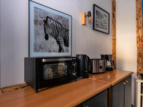 un four micro-ondes sur un comptoir avec une photo d'un zèbre dans l'établissement #213 LUX-Room - Zentrum Neuss - Nähe Düsseldorf Messe mit Netflix & Prime, à Neuss