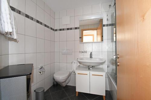 a white bathroom with a sink and a toilet at Sophia 1. Stock West in Riederalp