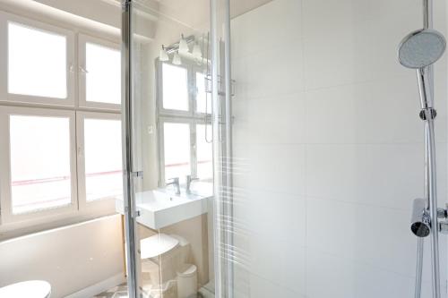 een badkamer met een douche, een wastafel en een spiegel bij SAINT DOMINIQUE PARIS 7 - BEST PLACE - BAIL MOBILITE in Parijs