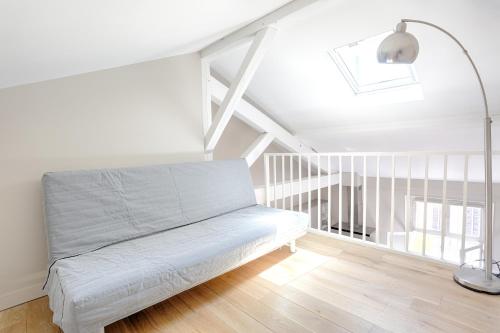 een witte kamer met een bed en een lamp bij SAINT DOMINIQUE PARIS 7 - BEST PLACE - BAIL MOBILITE in Parijs