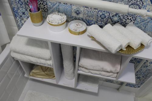 a white shelf with towels on it in a bathroom at Тіффані Апартаменти in Dnipro