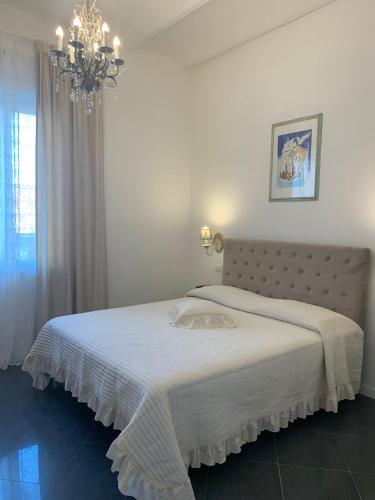 a bedroom with a white bed with a chandelier at Artemisia in Viareggio