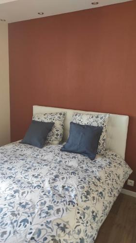 een bed met blauwe en witte lakens en kussens bij AUBIGNY SUR NERE in Aubigny-sur-Nère