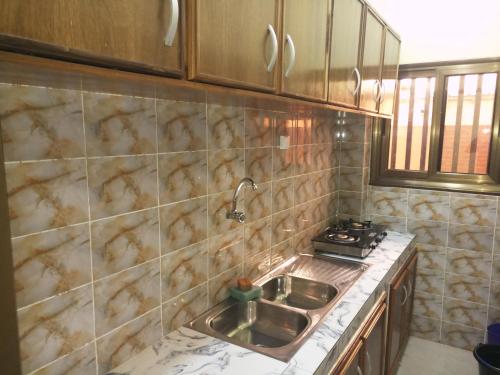 a kitchen with a sink and a stove at Résidence Lynda Prestige in Ouagadougou