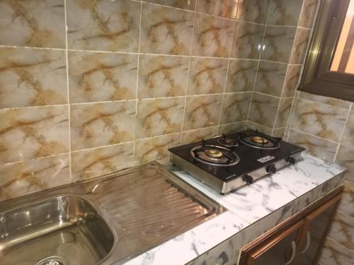 una cucina con una stufa su un bancone accanto a un lavandino di Résidence Lynda Prestige a Ouagadougou