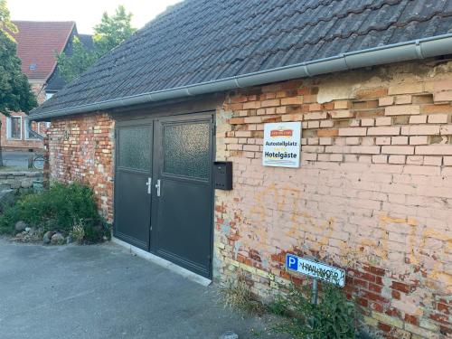 a brick building with a door and a sign on it at Ferienwohnungen im Gewölbe in Wismar