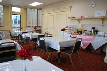 uma sala de jantar com mesas e cadeiras num restaurante em Amsterdam Hotel em Stamford