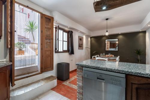 a kitchen with a counter and a large window at Town house with roof terrace and plunge pool in Alcaucín