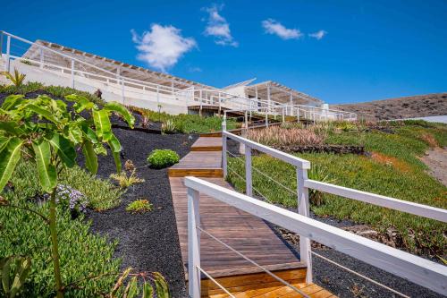 a wooden walkway leading up to a building with plants at Etti Paradise Suite Mediterraneo in Pájara