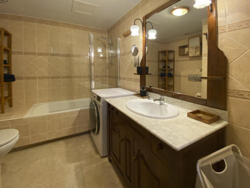 a bathroom with a sink and a toilet and a tub at BEACH FRONT GRANILLO - ocean view, garden, bright and comfortable, Wi-Fi in Costa Calma