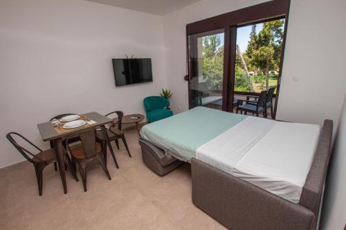 a bedroom with a bed and a table and a window at Zia Apartments in Bar