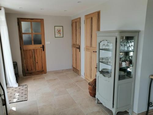 a room with a glass cabinet with dishes in it at Gites Lou Limbert in Valensole
