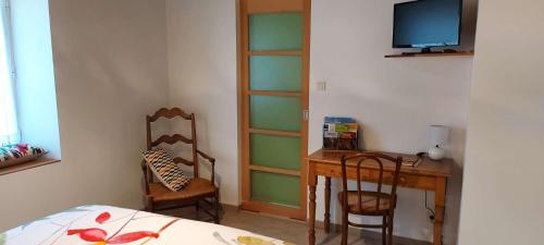 Dormitorio con escritorio, cama y TV en LES RÊVES BLEUS, 