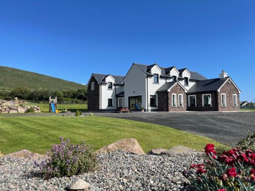 a house on a hill with a driveway and flowers at The Cé Hideout in Tralee