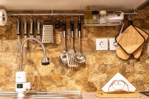un bancone della cucina con utensili appesi a un muro di ΟΝΕΙΡΟΠΑΓΙΔΑ-DREAM CATCHER a Áno Pavliána