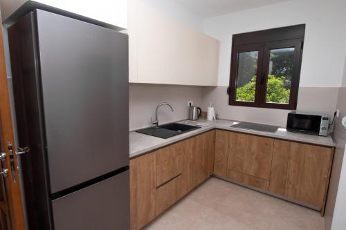 a kitchen with a refrigerator and a sink and a window at Zia Apartments in Bar