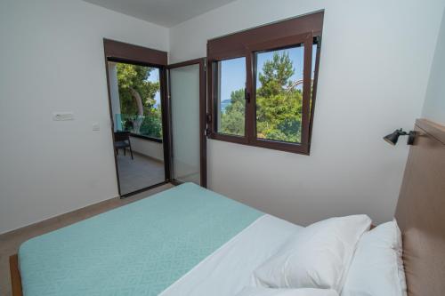a bedroom with a bed and two windows at Zia Apartments in Bar