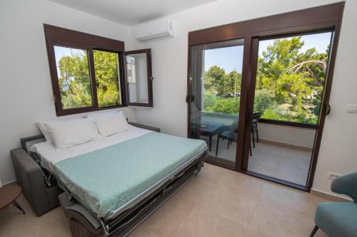 a bedroom with a bed and a balcony with a table at Zia Apartments in Bar