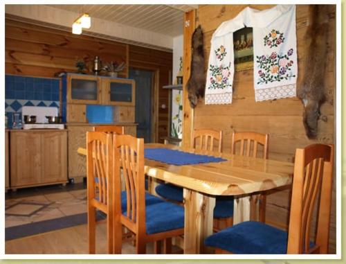 a dining room with a wooden table and chairs at Dom Zajezdny in Białowieża