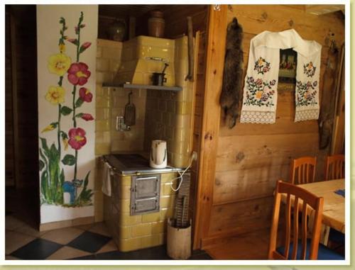 a kitchen with a stove and a table in a room at Dom Zajezdny in Białowieża