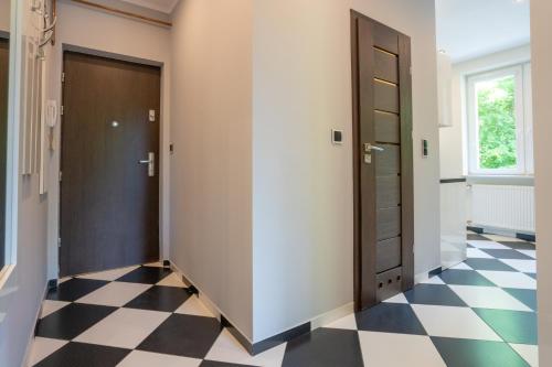 un pasillo con puerta y suelo a cuadros en Karkonosky Apartamenty- Salamandra, en Szklarska Poręba