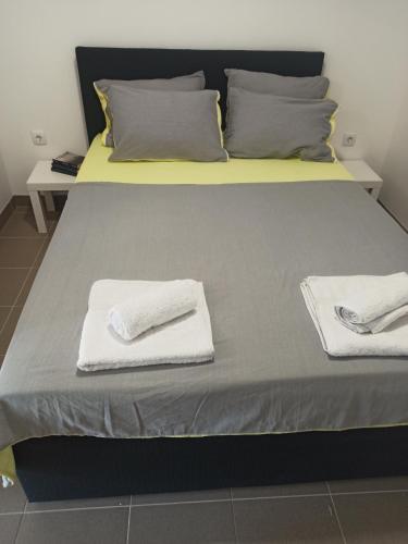 - un lit avec 2 serviettes blanches dans l'établissement Apartmani Drinski biseri Vrhpolje, à Vrhpolje