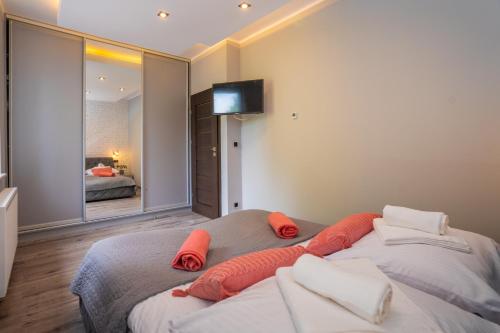 Un dormitorio con dos camas con almohadas rojas sobre ellas. en Karkonosky Apartamenty- Salamandra, en Szklarska Poręba