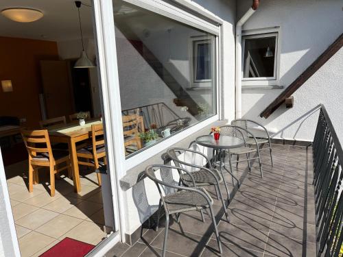 einen Balkon mit Stühlen, einem Tisch und einem Esszimmer in der Unterkunft Reis - feine Weine "Am Weingut" in Briedel
