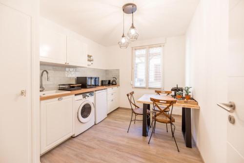 une cuisine avec une table et une buanderie dans l'établissement Relax And Go - Strasbourg Train Station, à Strasbourg